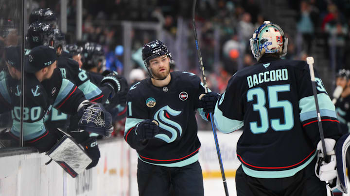Feb 4, 2025; Seattle, Washington, USA; Seattle Kraken center Shane Wright (51) celebrates with goaltender Joey Daccord (35) after scoring a goal against the Detroit Red Wings during the third period at Climate Pledge Arena. Mandatory Credit: Steven Bisig-Imagn Images
