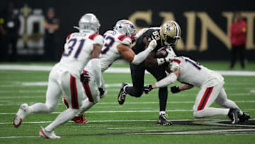 New England Patriots linebackers Christian Elliss (53) and linebacker Robert Spillane combine to tackle New Orleans Saints tight end Juwan Johnson.