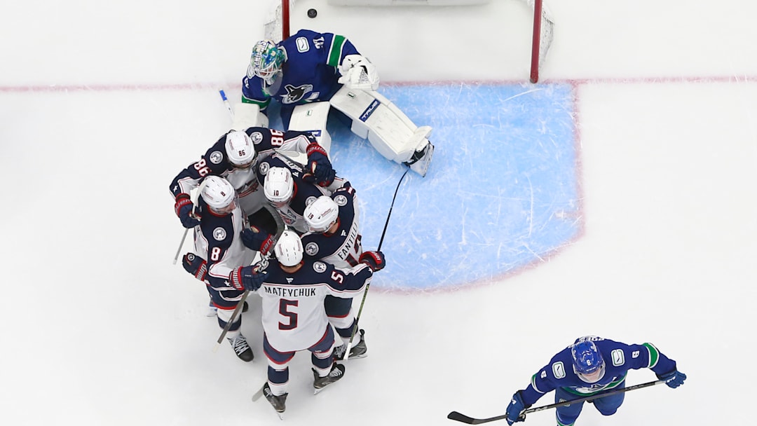 The Blue Jackets celebrate a goal in front of Vancouver goaltender Kevin Lankinen