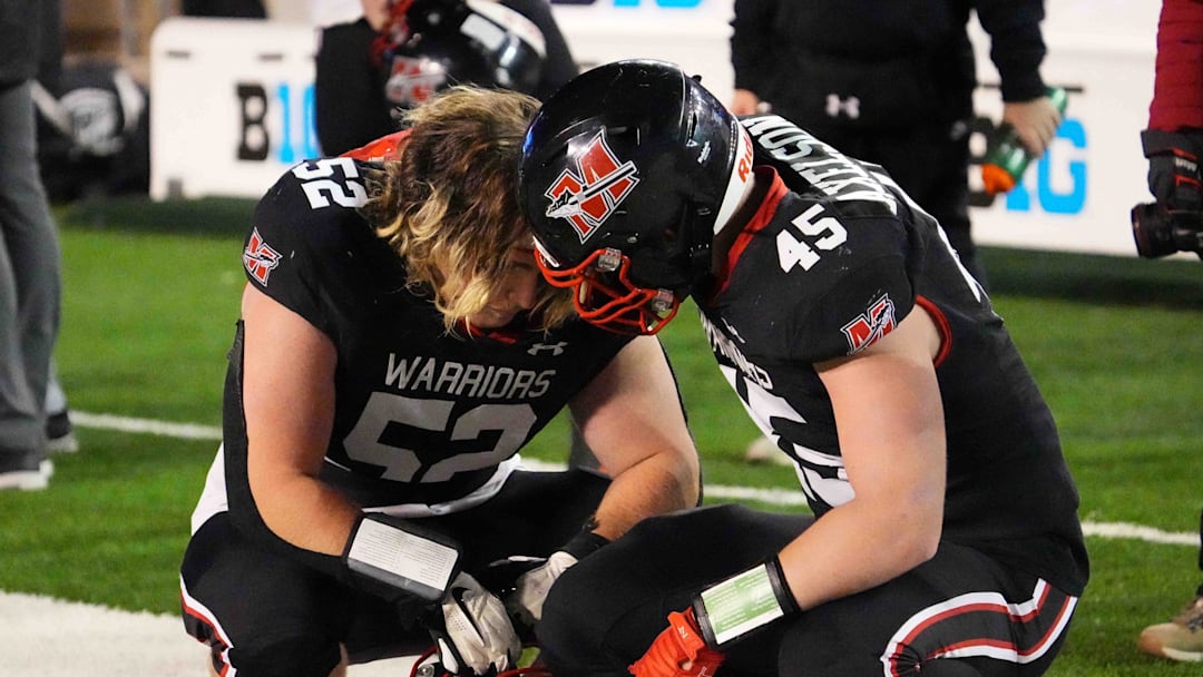 Muskego's Brody Axelson (45) consoles Kellen DeBruine (52) after their team's 25-18 loss to Bay Port in the WIAA Division 1 state championship football game at Camp Randall Stadium in Madison on Friday, Nov. 22, 2024.