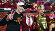 Nov 29, 2025; Los Angeles, California, USA; Southern California Trojans head coach Lincoln Riley (left) poses with Spirit of Troy marching band director James Vogel (center) and mascot Tommy Trojan after the game against the UCLA Bruins at United Airlines Field at Los Angeles Memorial Coliseum. Mandatory Credit: Kirby Lee-Imagn Images