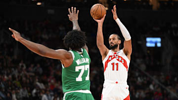 Oct 10, 2025; Toronto, Ontario, CAN;  Toronto Raptors center Olivier Sarr (11) shoots the ball over Boston Celtics center Amari Williams (77) in the second half at Scotiabank Arena. Mandatory Credit: Dan Hamilton-Imagn Images