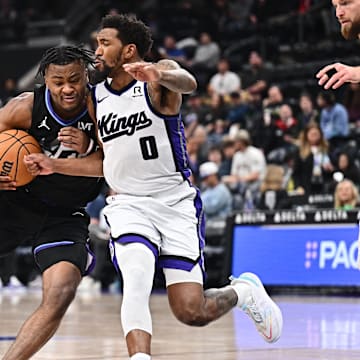 Feb 26, 2025; Salt Lake City, Utah, USA;  Utah Jazz guard Isaiah Collier (13) attempts to drive around Sacramento Kings guard Malik Monk (0) in the second half at Delta Center. Mandatory Credit: Jamie Sabau-Imagn Images