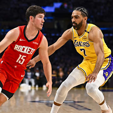 Apr 11, 2025; Los Angeles, California, USA; Houston Rockets guard Reed Sheppard (15) drives the ball against Los Angeles Lakers guard Gabe Vincent (7) during the second half at Crypto.com Arena. Mandatory Credit: Jonathan Hui-Imagn Images