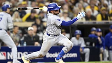 Oct 8, 2024; San Diego, California, USA; Los Angeles Dodgers shortstop Miguel Rojas (11) singles in the third inning against the San Diego Padres during game three of the NLDS for the 2024 MLB Playoffs at Petco Park.  Mandatory Credit: Denis Poroy-Imagn Images