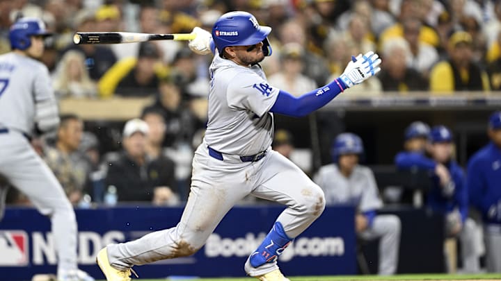 Oct 8, 2024; San Diego, California, USA; Los Angeles Dodgers shortstop Miguel Rojas (11) singles in the third inning against the San Diego Padres during game three of the NLDS for the 2024 MLB Playoffs at Petco Park.  Mandatory Credit: Denis Poroy-Imagn Images