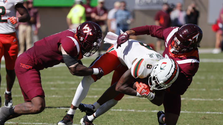 Oct 15, 2022; Blacksburg, Virginia, USA;  Virginia Tech Hokies linebacker Dax Hollifield (4) and defensive back Brion Murray (8) combine top bring down Miami Hurricanes wide receiver Frank Ladson Jr. (8) during the second quarter at Lane Stadium. Mandatory Credit: Reinhold Matay-USA TODAY Sports