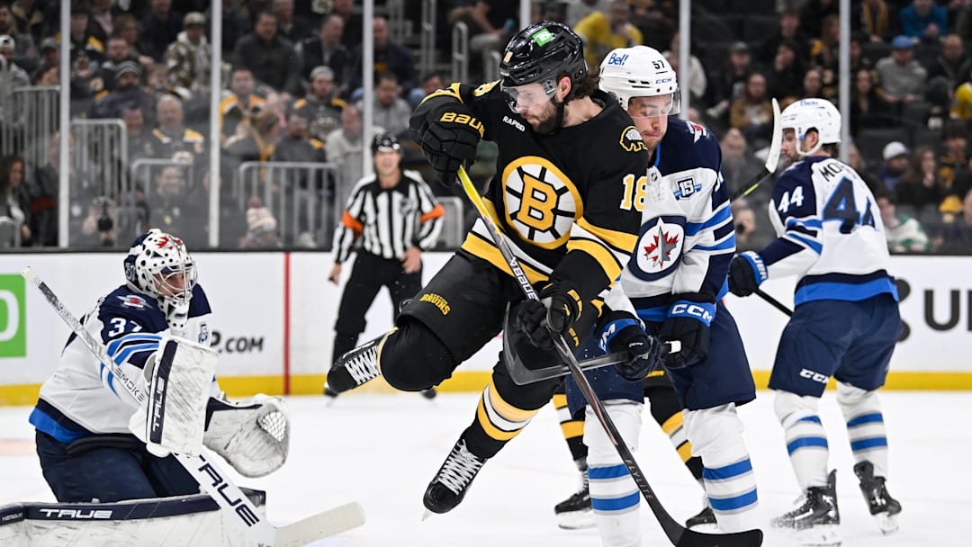 Mar 19, 2026; Boston, Massachusetts, USA; Boston Bruins center Pavel Zacha (18) leaps out of the way for a shot against Winnipeg Jets goaltender Connor Hellebuyck (37) during the first period at TD Garden. Mandatory Credit: Eric Canha-Imagn Images