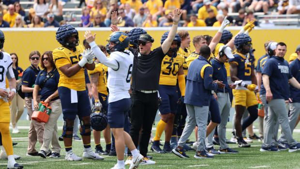 West Virginia University senior quarterback Garrett Greene celebrates a touchdown with honorary coach Pat McAfee during the 2024 Gold-Blue Spring Game.