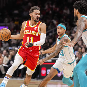 Apr 10, 2024; Atlanta, Georgia, USA; Atlanta Hawks guard Trae Young (11) controls the ball against Charlotte Hornets guard Tre Mann (23) during the first half at State Farm Arena. Mandatory Credit: Dale Zanine-USA TODAY Sports