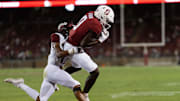 Sep 3, 2022; Stanford, California, USA;  Stanford Cardinal wide receiver Mudia Reuben (0) catches the ball for a touchdown during the fourth quarter against Colgate Raiders defensive back Taitwoine Sanders (17) at Stanford Stadium. Mandatory Credit: Stan Szeto-Imagn Images