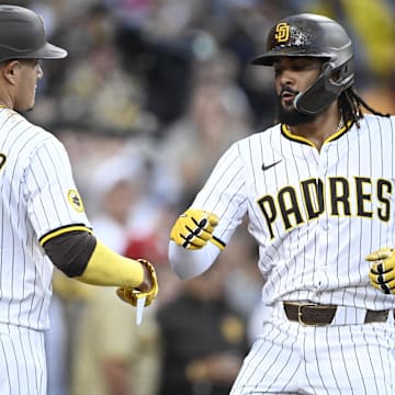 Jul 10, 2025; San Diego, California, USA; San Diego Padres right fielder Fernando Tatis Jr. (23) is congratulated by  Manny Machado (13) after hitting a solo home run during the third inning against the Arizona Diamondbacks at Petco Park. Mandatory Credit: Denis Poroy-Imagn Images a