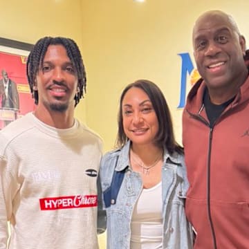 Washington Commanders owner Magic Johnson (right) meets with quarterback Jayden Daniels (left) and Daniels' mother Regina Jackson (center).