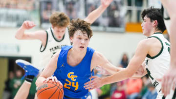 Greenfield-Central Cougars Braylon Mullins (24) dribbles the ball down the court amid defenders on Friday, Jan. 26, 2024, during the game at Pendleton Heights High School in Pendleton. The Greenfield-Central Cougars defeated the Pendleton Heights Arabians 74-72 in double overtime.