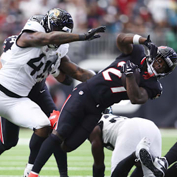 Nov 9, 2025; Houston, Texas, USA; Houston Texans running back Woody Marks (27) runs with the ball as Jacksonville Jaguars defensive end Josh Hines-Allen (41) attempts to make a tackle during the fourth quarter at NRG Stadium. Mandatory Credit: Troy Taormina-Imagn Images