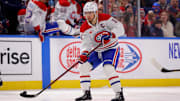 Mar 1, 2025; Buffalo, New York, USA;  Montreal Canadiens center Nick Suzuki (14) flips the puck up ice during the first period against the Buffalo Sabres at KeyBank Center. Mandatory Credit: Timothy T. Ludwig-Imagn Images