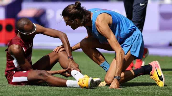 Italy's Gianmarco Tamberi (pictured left) checks on Qatar's Mutaz Barsham after the latter suffered an injury during the men's high jump qualification round at the Stade de France in the Paris Olympics on Wednesday, August 7, 2024. 