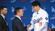 Jan 22, 2025; Los Angeles, CA, USA;  L-R; Brandon Gomes, president of baseball operations and general manager Andrew Friedman shake hands with Los Angeles Dodgers pitcher Roki Sasaki (11) during an introductory press conference at Dodger Stadium. Mandatory Credit: Jayne Kamin-Oncea-Imagn Images  