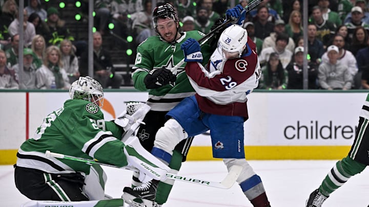 Apr 21, 2025; Dallas, Texas, USA; Dallas Stars center Matt Duchene (95) checks Colorado Avalanche center Nathan MacKinnon (29) in front of goaltender Jake Oettinger (29) during the first period in game two of the first round of the 2025 Stanley Cup Playoffs at American Airlines Center. Mandatory Credit: Jerome Miron-Imagn Images