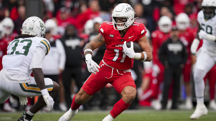 Oct 25, 2025; Cincinnati, Ohio, USA;  Cincinnati Bearcats tight end Joe Royer (11) carries the ball after making a catch against Baylor Bears safety DJ Coleman (33) in the first half at Nippert Stadium. Mandatory Credit: Aaron Doster-Imagn Images
