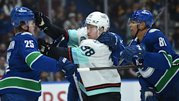 Apr 2, 2025; Vancouver, British Columbia, CAN;  Vancouver Canucks defenseman Elias Pettersson (25) fights Seattle Kraken forward Jani Nyma (38) during the third period at Rogers Arena. Mandatory Credit: Simon Fearn-Imagn Images