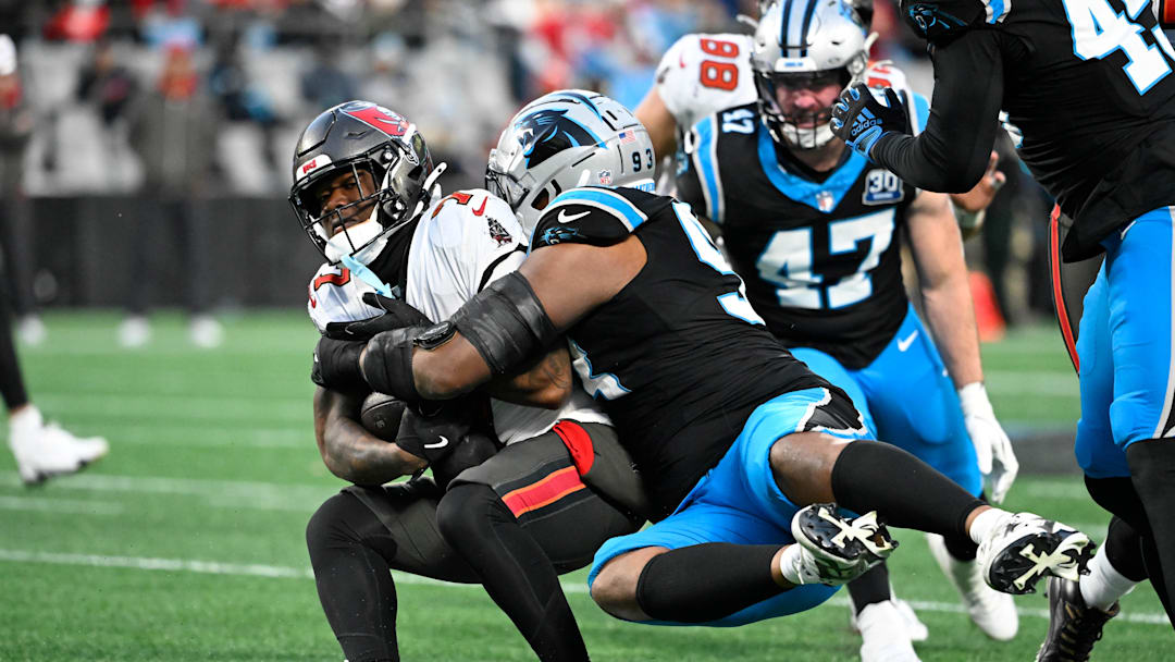 Dec 1, 2024; Charlotte, North Carolina, USA;  Tampa Bay Buccaneers running back Bucky Irving (7) is tackled by Carolina Panthers defensive end LaBryan Ray (93) in the second quarter at Bank of America Stadium. Mandatory Credit: Bob Donnan-Imagn Images