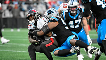 Dec 1, 2024; Charlotte, North Carolina, USA;  Tampa Bay Buccaneers running back Bucky Irving (7) is tackled by Carolina Panthers defensive end LaBryan Ray (93) in the second quarter at Bank of America Stadium. Mandatory Credit: Bob Donnan-Imagn Images