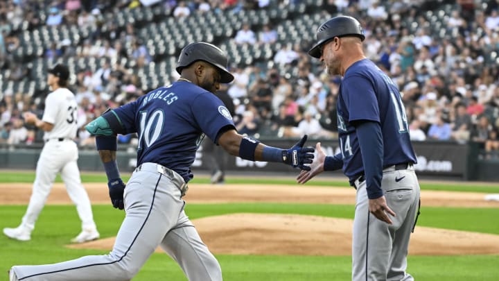 Seattle Mariners outfielder Victor Robles (10) high fives Seattle Mariners third base coach Manny Acta (14) after he homers against the Chicago White Sox during the first inning at Guaranteed Rate Field in 2024.