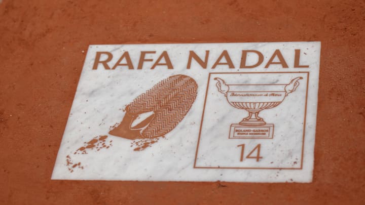 A detail view of of a plaque for Rafael Nadal on day 12 at Roland Garros Stadium with the iconic red clay courts displayed A detail view of of a plaque for Rafael Nadal on day 12 at Roland Garros Stadium with the iconic red clay courts displayed