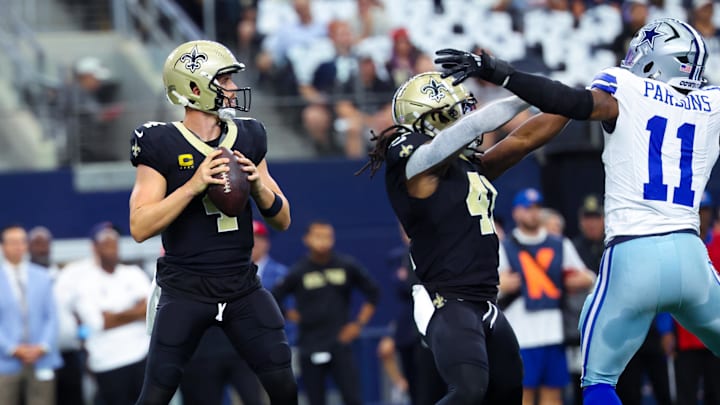 Sep 15, 2024; Arlington, Texas, USA; New Orleans Saints quarterback Derek Carr (4) throws as Dallas Cowboys linebacker Micah Parsons (11) tries to pressure during the first quarter at AT&T Stadium. Mandatory Credit: Kevin Jairaj-Imagn Images