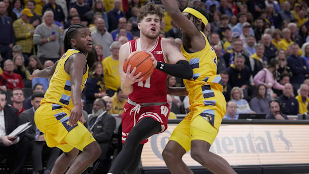 Wisconsin guard Max Klesmit (11) drives past Marquette guard Chase Ross (2) during the second half of their game