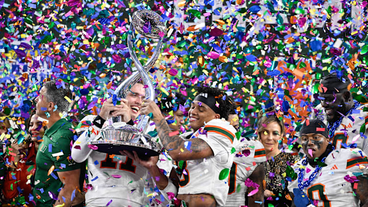 Miami quarterback Carson Beck and defensive back Jakobe Thomas lift the Cotton Bowl trophy after defeating Ohio State.
