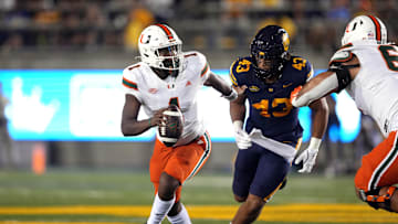 Oct 5, 2024; Berkeley, California, USA; Miami Hurricanes quarterback Cam Ward (1) scrambles against California Golden Bears linebacker Ryan McCulloch (43) during the second quarter at California Memorial Stadium. Mandatory Credit: Darren Yamashita-Imagn Images