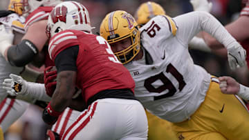 Minnesota defensive lineman Deven Eastern (91) tackles Wisconsin running back Tawee Walker (3) for no gain during the fourth quarter of their game at Camp Randall Stadium Friday, November 29, 2024 in Madison, Wisconsin. Minnesota beat Wisconsin 24-7.