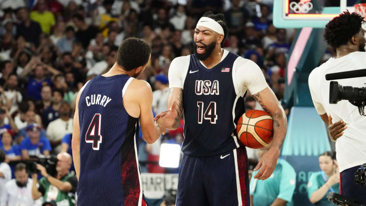 Aug 10, 2024; Paris, France; United States centre Anthony Davis (14) and shooting guard Stephen Curry (4) celebrate after defeating France in the men's basketball gold medal game during the Paris 2024 Olympic Summer Games at Accor Arena. Mandatory Credit: Rob Schumacher-USA TODAY Sports