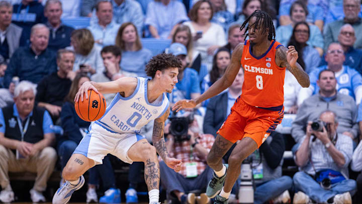 Mar 3, 2026; Chapel Hill, North Carolina, USA; North Carolina Tar Heels guard Kyan Evans (0) dribbles against Clemson Tigers forward Dallas Thomas (8) during the first half at Dean E. Smith Center. Mandatory Credit: Scott Kinser-Imagn Images