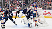 Dec 6, 2025; Edmonton, Alberta, CAN; Edmonton Oilers center Connor McDavid (97) and Winnipeg Jets goalie Eric Comrie (1) collide during the first period at Rogers Place. Mandatory Credit: Walter Tychnowicz-Imagn Images