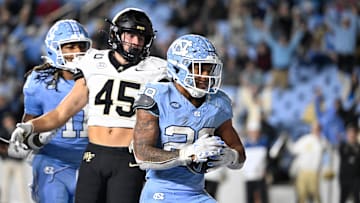 Nov 16, 2024; Chapel Hill, North Carolina, USA; North Carolina Tar Heels running back Omarion Hampton (28) scores a touchdown as Wake Forest Demon Deacons defensive back Nick Andersen (45) defends in the fourth quarter at Kenan Memorial Stadium. 