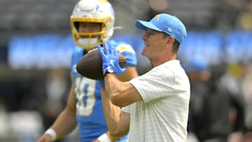 Sep 8, 2024; Inglewood, California, USA; Los Angeles Chargers head coach Jim Harbaugh catches the ball for quarterback Justin Herbert (10) as he warms up prior to the game against the Los Angeles Chargers at SoFi Stadium. Mandatory Credit: Jayne Kamin-Oncea-Imagn Images