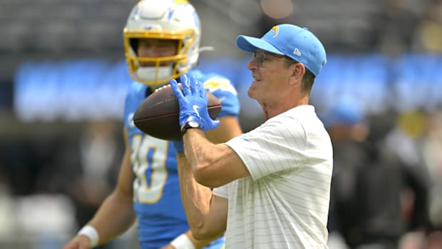  Los Angeles Chargers head coach Jim Harbaugh catches the ball for quarterback Justin Herbert (10)