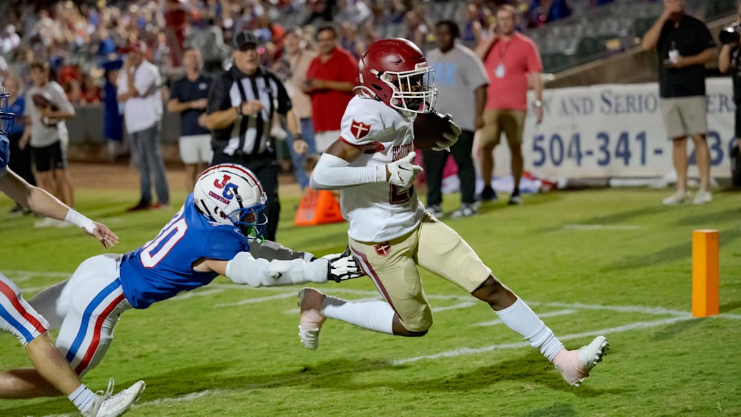 Oct 27, 2023; Metairie, LA, USA; Brother Martin Crusaders wide receiver Easton Royal (23) scores a touchdown against John Curtis Patriots linebacker Benjamin Barron (30) during the first quarter at The Shrine on Airline. Mandatory Credit: Matthew Hinton-Imagn Images