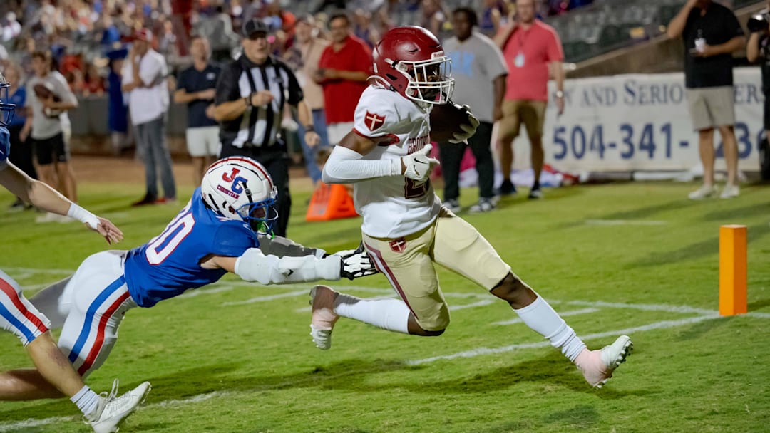 Oct 27, 2023; Metairie, LA, USA; Brother Martin Crusaders wide receiver Easton Royal (23) scores a touchdown against John Curtis Patriots linebacker Benjamin Barron (30) during the first quarter at The Shrine on Airline. Mandatory Credit: Matthew Hinton-Imagn Images