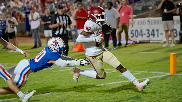 Oct 27, 2023; Metairie, LA, USA; Brother Martin Crusaders wide receiver Easton Royal (23) scores a touchdown against John Curtis Patriots linebacker Benjamin Barron (30) during the first quarter at The Shrine on Airline. Mandatory Credit: Matthew Hinton-Imagn Images