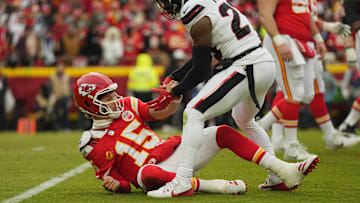Jan 18, 2025; Kansas City, Missouri, USA; Houston Texans safety Eric Murray (23) assists Kansas City Chiefs quarterback Patrick Mahomes (15) up from the ground after a play during the second quarter of a 2025 AFC divisional round game at GEHA Field at Arrowhead Stadium. Mandatory Credit: Jay Biggerstaff-Imagn Images