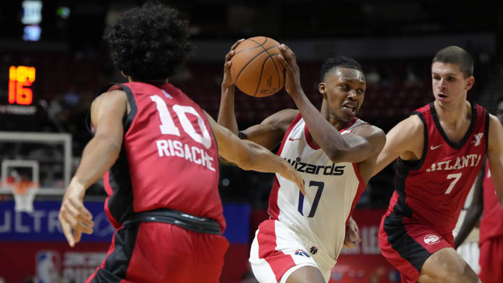 Jul 12, 2024; Las Vegas, NV, USA;  Washington Wizards guard Bub Carrington (17) drives the ball against Atlanta Hawks guard Nikola Durisic (7) and forward Zaccharie Risacher (10) during the second half at Thomas & Mack Center. Mandatory Credit: Lucas Peltier-USA TODAY Sports