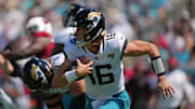 Sep 26, 2021; Jacksonville, Florida, USA; Jacksonville Jaguars quarterback Trevor Lawrence (16) scrambles with the ball against the Arizona Cardinals during the first half at TIAA Bank Field. Mandatory Credit: Jasen Vinlove-Imagn Images