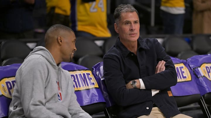 Nov 21, 2024; Los Angeles, California, USA;  Los Angeles Lakers general manager Rob Pelinka, right, talks with Leroy Sims, director of player performance & health, prior to the game against the Orlando Magic at Crypto.com Arena. Mandatory Credit: Jayne Kamin-Oncea-Imagn Images