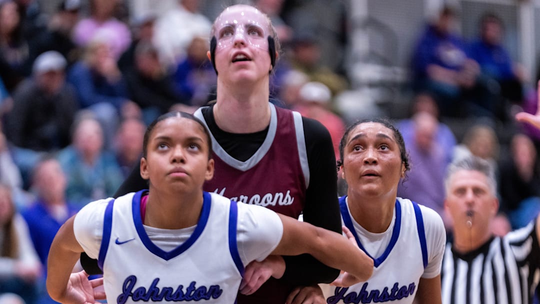 Johnston's Adaya Phillips (20), Dowling’s Ellie Muller (23) and Johnston's Jenica Lewis (10) look to the basket after a pair of Dowling free throws on Dec. 16, 2025, at Johnston High School.