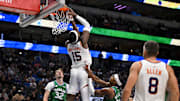 Nov 12, 2025; Dallas, Texas, USA; Phoenix Suns center Mark Williams (15) makes a reverse dunk as Dallas Mavericks forward Cooper Flagg (32) and guard Brandon Williams (10) looks on during the second half at the American Airlines Center. Mandatory Credit: Jerome Miron-Imagn Images