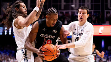 Xavier Musketeers forward Tre Carroll (12) and Xavier Musketeers forward Filip Borovicanin (4) cover Cincinnati Bearcats forward Baba Miller (18) in the first half of the NCAA basketball game at the Cintas Center in Cincinnati on Dec. 5, 2025.